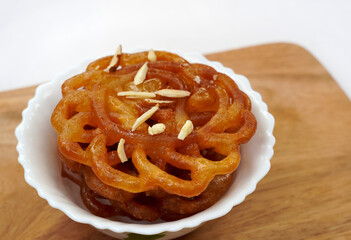 Jalebi, also known as zulbia or Imarati, is a sweet popular food in India. Popular Indian festival food or dessert. Served in a plate over colourful or wooden background. Selective focus