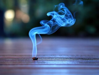 Wispy blue smoke rising from a small object on a wooden surface