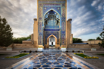 Samarkand, Uzbekistan - 05 June 2024: View of the Gur-e-Amir Mausoleum, its turquoise and azure mosaics shimmer under the soft glow of dawn, reflecting in the patterned stone courtyard.