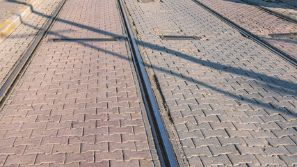 Tram tracks with tiles laid between the rails. Urban transport and roads for trams. View of the road and rails. Tram tracks.