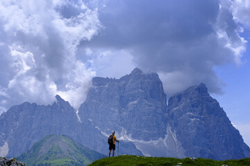 Hiker in front of cloud-covered Mt. Pelmo, Dolomites, Italy