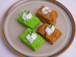 Getuk on brown plate. Getuk is a traditional Indonesian snack made from mashed boiled cassava,...