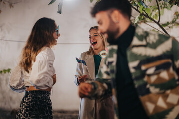 Friends enjoying an outdoor meet up, smiling, and engaging in casual and joyful interactions.