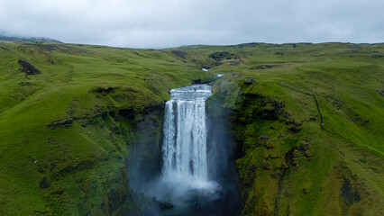 Majestic Skogafoss waterfall surrounded by lush green landscapes in Iceland