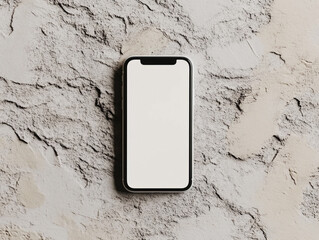 A silver smartphone with a blank white screen lies on a textured surface under soft lighting.