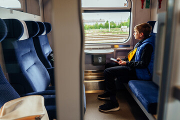 Teen boy holding phone and looking outside