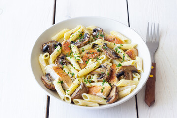 Penne pasta with chicken and mushrooms in creamy sauce. Italian cuisine. Recipe.