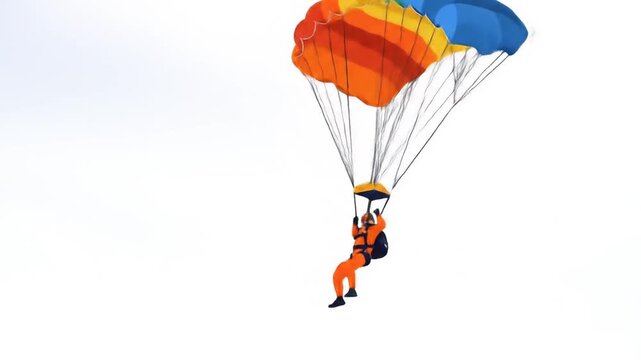 Person skydiving with colorful parachute in open sky during daytime