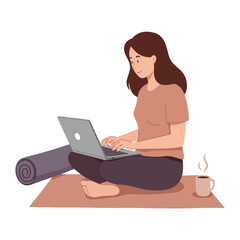Woman sitting on mat working on laptop with hot drink