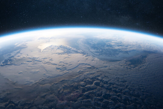 Stunning view of Earth’s atmosphere and cloud formations from space. The planet’s curvature is visible against the dark starry sky, showcasing the beauty and fragility of our planet.