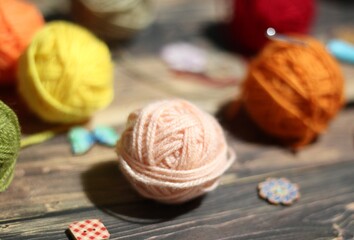 Different colors clews balls yarn on wooden background photo 