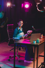 Young female podcaster recording a live session in a professional home studio environment...
