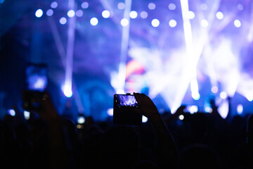 Crowd at concert and colorful stage lights.