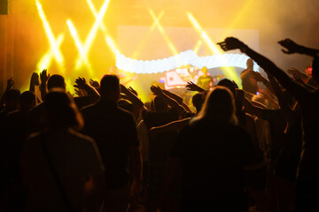 Crowd at concert and colorful stage lights.