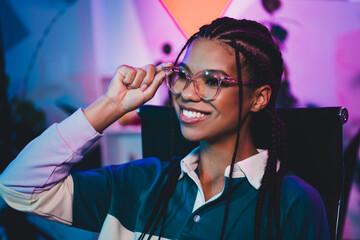 Stylish young female professional in modern setting with vibrant neon lighting, showcasing media...
