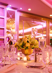Elegant table setting with floral centerpiece and candles at a festive indoor event