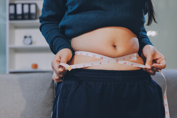 woman's hand holding excessive belly fat, overweight concept