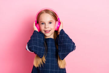 Smiling young girl headphones on pink background - vibrant and happy music lifestyle concept