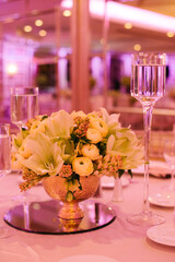 Elegant table setting featuring flowers and glassware in a beautifully decorated venue during an evening event