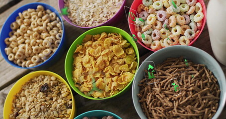 Displaying eight colorful cereal bowls lining wooden table, showcasing various cereal types