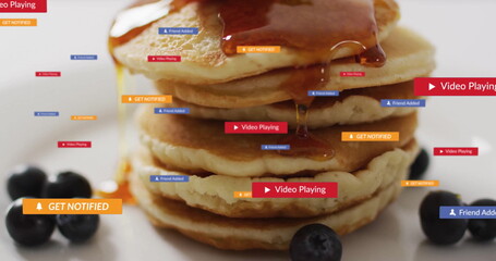 Five-pancake stack dripping syrup on tabletop, with blueberries and floating notification labels