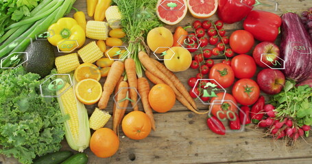 Displaying wooden tabletop featuring fresh lettuce, avocado, tomatoes, carrots and eco icons