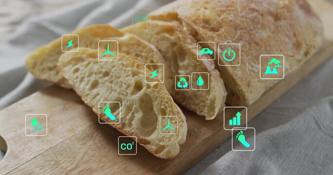 Showing crusty baguette slicing on board over grey linen on kitchen table, with eco overlay icons