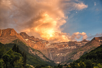 Dramatic sunset with illuminated clouds of the Cirque de Gavarnie, a UNESCO World Heritage site with France's highest waterfall in the French Pyrenees
