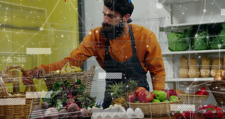 Reaching bearded vendor wearing apron grabbing banana in produce shop, with digital graphics