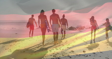 Six adult surfers walking in swimwear along sandy sunset shoreline, carrying surfboards and leashes