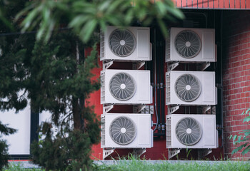 Air conditioner compressor installed on the wall of a building.