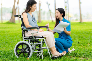 Caregiver takes elderly in wheelchair to walk in the park for health therapy, insurance concept for the elderly, happy retirement