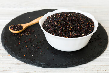 quinoa seeds in bowl and spoon on colored background. Healthy kinwa in small bowl. Healthy superfood