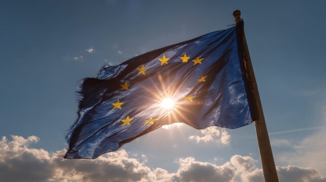 European Union flag waving with sun shining through stars