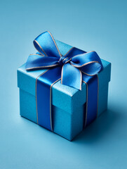 Elegant blue gift box tied with dark ribbon on light blue backdrop