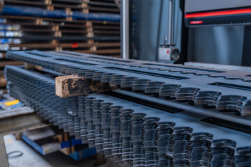Pièces industrielles métalliques découpées avec précision par machine laser dans un atelier de fabrication moderne.