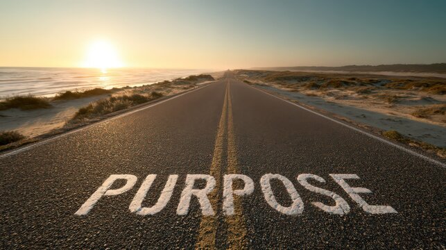 A road leading to the horizon with the word purpose painted on it near the beach at sunset light