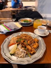 Close-Up of Pad Thai with Tofu and Lime in a Cozy Restaurant