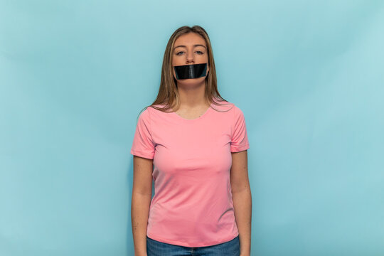 Woman wearing pink t-shirt promoting Breast Cancer Awareness with taped mouth