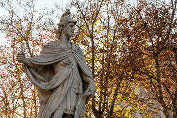 Fototapeta premium Madrid, Spain. Statue of Euric, 5th-century Visigothic king, standing in Plaza de Oriente with an autumnal background of orange and brown foliage from surrounding trees