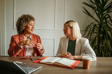 Two businesswomen discussing business strategy in modern office