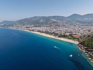 Obraz premium Aerial drone view of Cleopatra Beach in Alanya, Turkey. Alanya turquoise sea, sandy beach, cliffs, hills with caves, and the coastline during sunny summer day from above. Summer Mediterranean Sea.