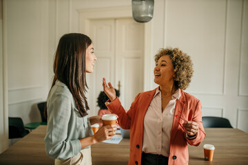Businesswomen talking and drinking coffee during office break