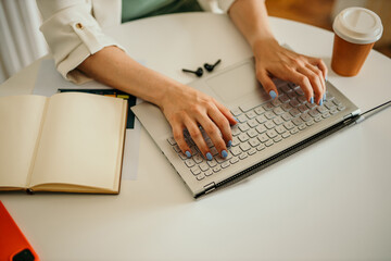 Office worker typing on laptop keyboard, working on project