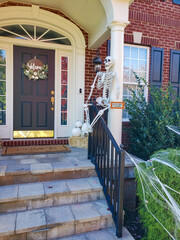 Skeleton and cobweb on the threshold of the house. Decoration of the decorated house for Halloween.
