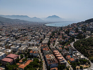 Aerial view of Alanya city in Turkey. Dense urban buildings, Mediterranean coastline, green hills...