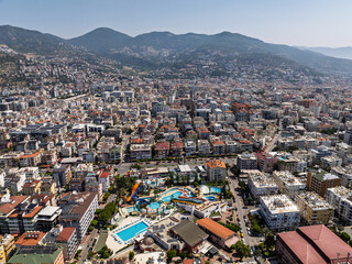 Aerial view of Alanya city in Turkey. Dense urban buildings, Mediterranean coastline, green hills...