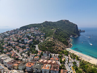 Aerial view of Alanya city in Turkey. Dense urban buildings, Mediterranean coastline, green hills...