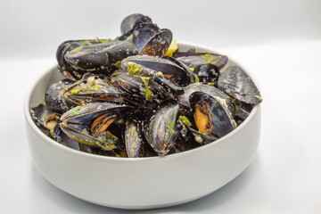 Steamed mussels in white wine and herbs closeup.