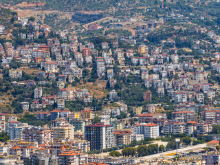 Aerial view of Alanya city in Turkey. Dense urban buildings, Mediterranean coastline, green hills...